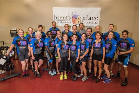 group photo of century riders for Club greenwood roadless ride for brent's place. standing next to bikes and a banner for brent's place