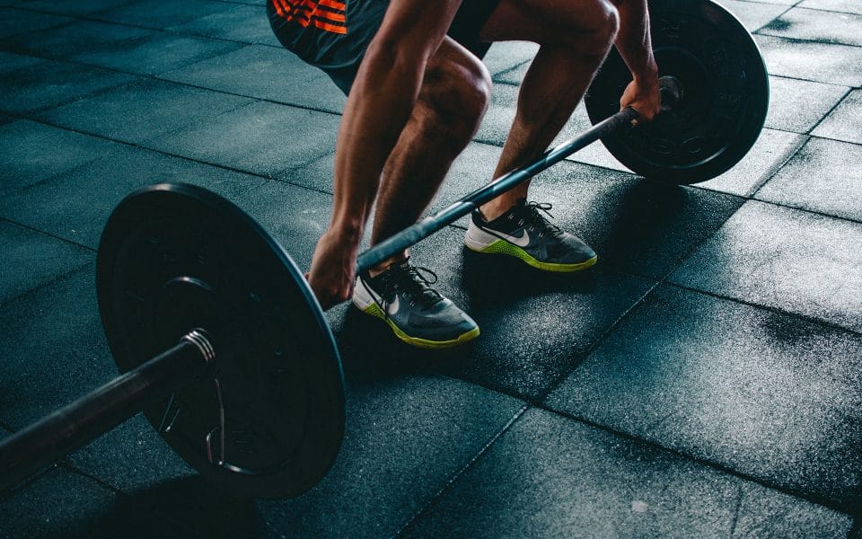 man lifting barbell in gym
