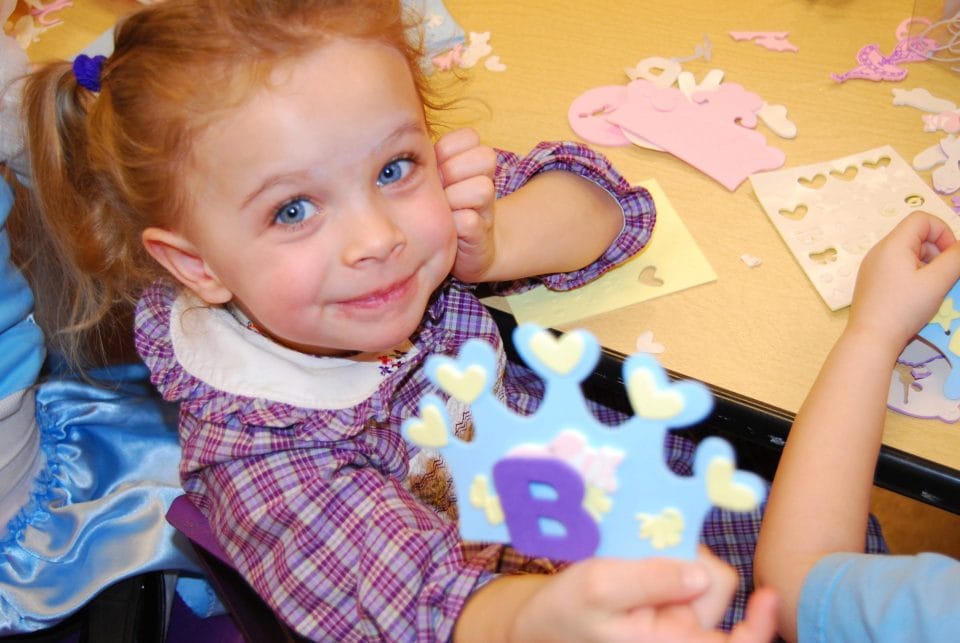 little girl making crafts during an arts and crafts birthday party