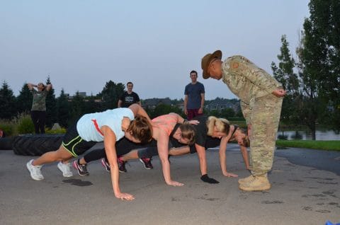 women doing push ups during boot camp while Rob Blue instructs in drill instructor uniform