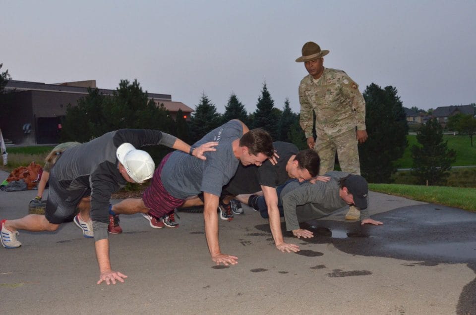 men doing push ups during boot camp while Rob Blue instructs in drill instructor uniform
