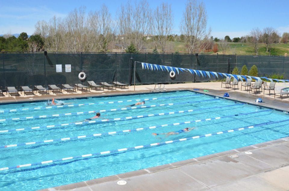 people swimming laps in club greenwood outdoor pool