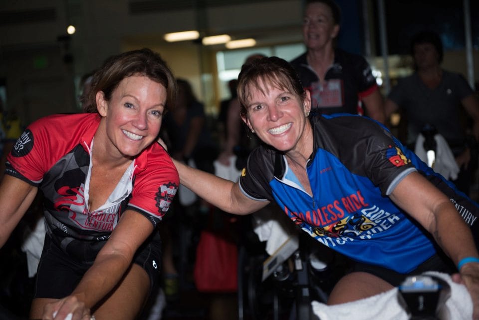 two women smiling on cycling bikes during the roadless right fundraiser for brents place
