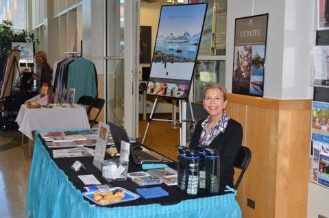 woman sitting at a table selling vacations at the business fair