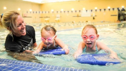 kids swimming in indoor pool with swim instructor jen barrow