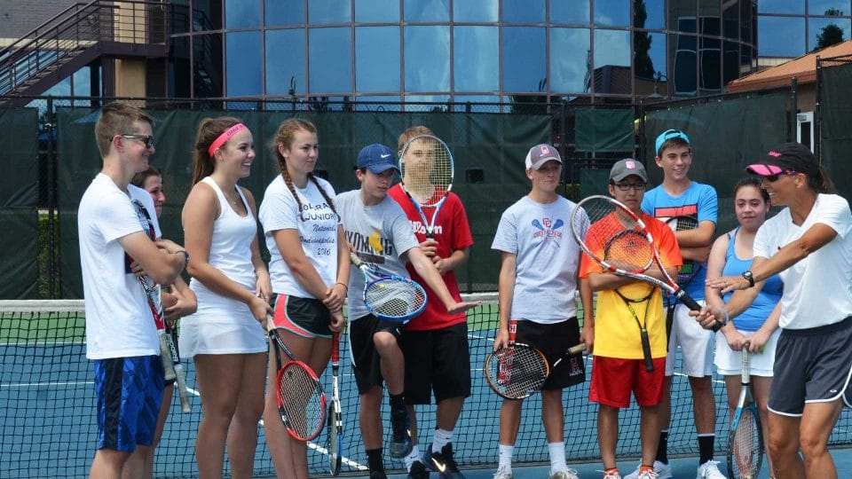 tennis pro teaching group of high schoolers
