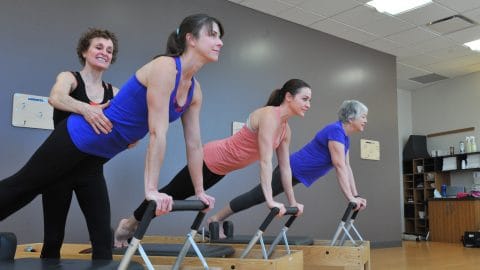 women in pilates class on reformers with pam oliver pilates instructor