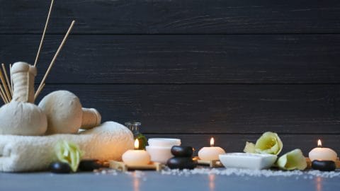 spa with candles, flowers, and stones