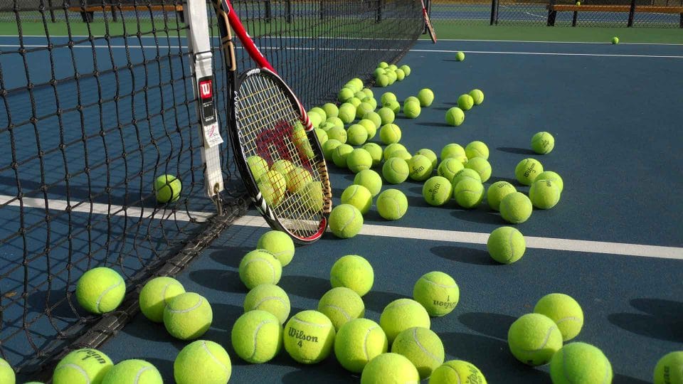 tennis balls and racquet on court