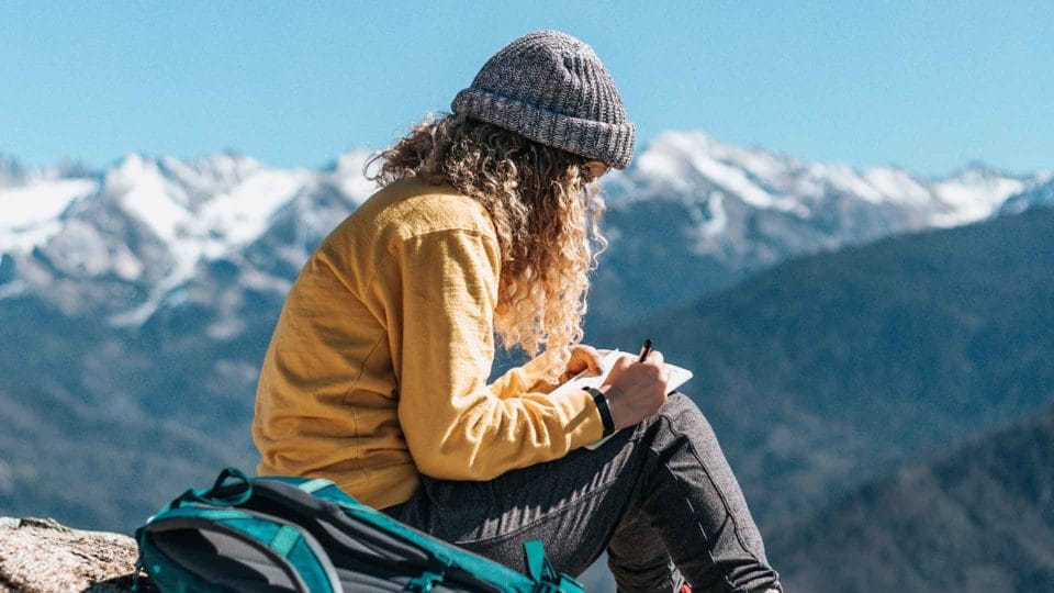 woman journaling in the mountains