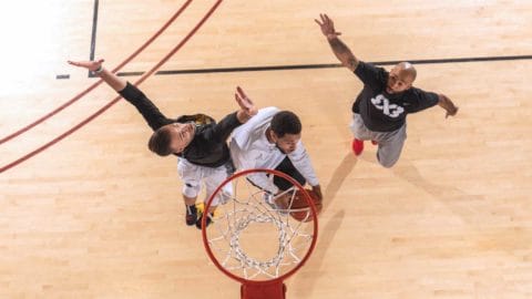 three adults playing basketball at club greenwood