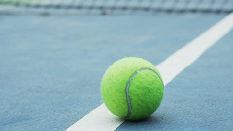 tennis ball on blue outdoor court