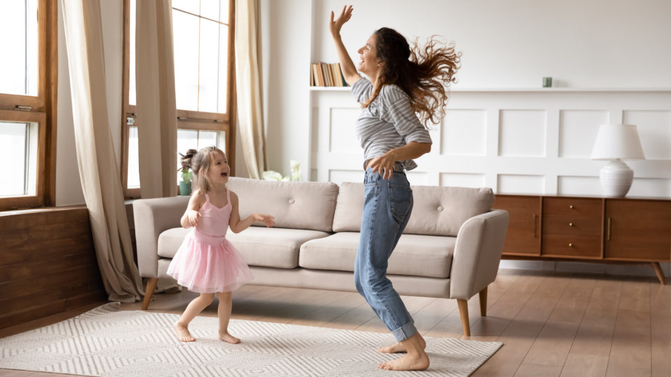 Mom dancing with daughter in living room