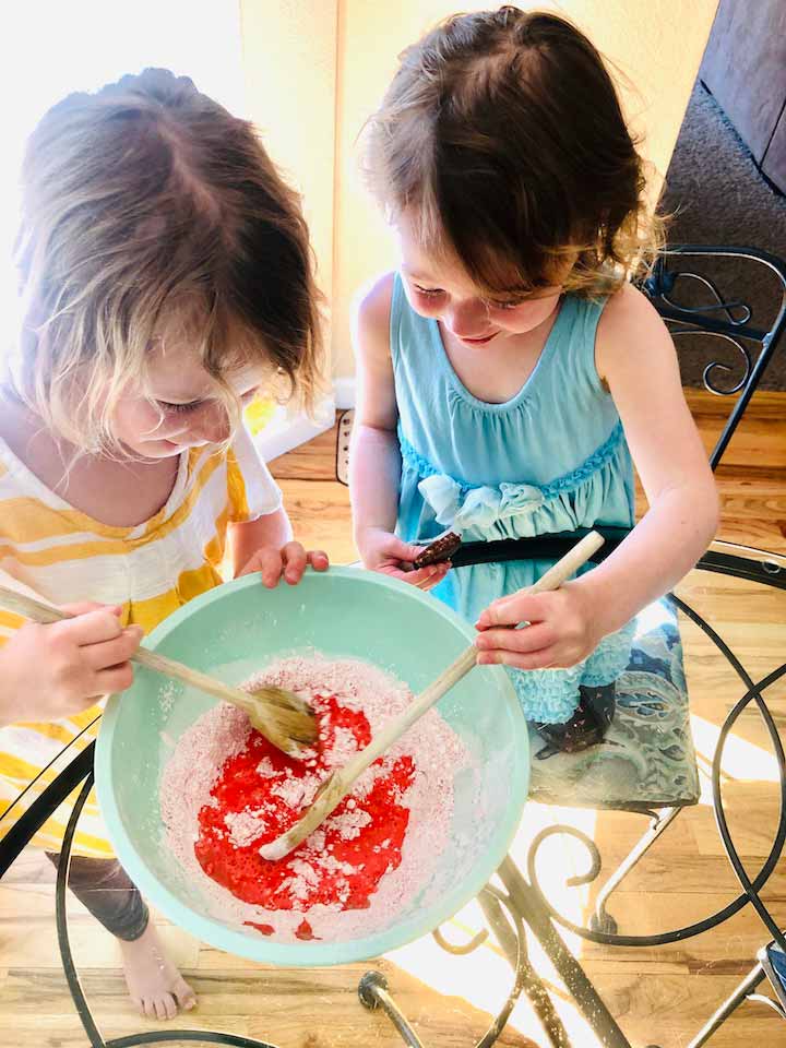 little girls mixing ingredients in a mixing bowl during daytime