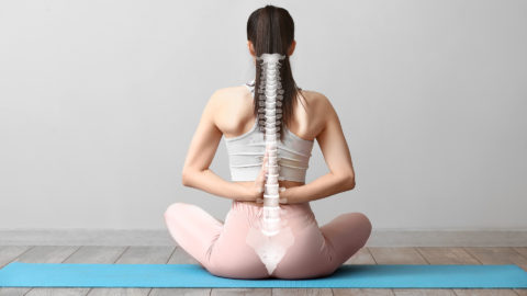 Woman in yoga pose with spine overlay on her back