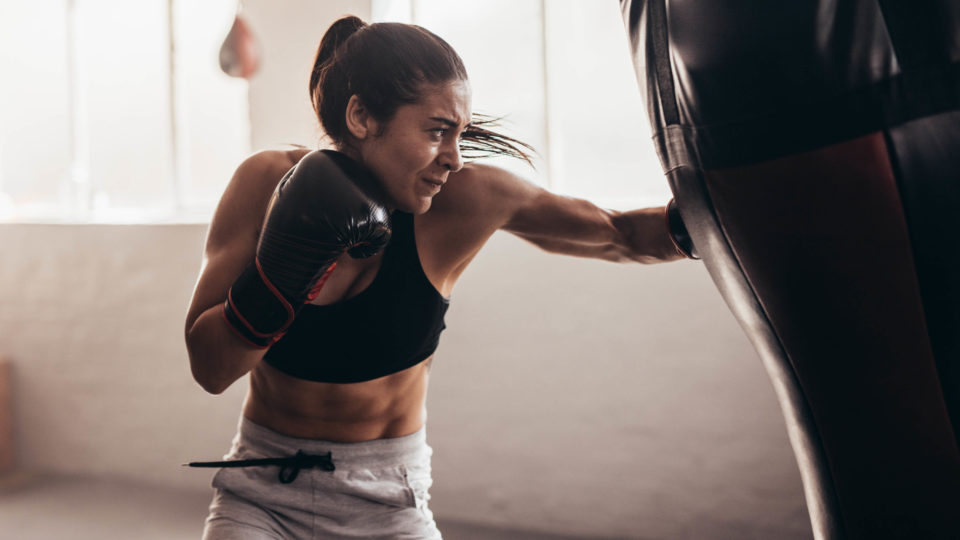 woman boxing with a punching bag in a room