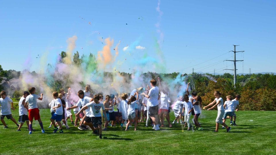 kids playing outside in the Summer on the grass during a color run