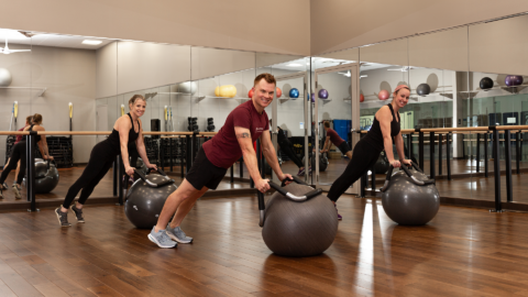 small group performing an exercise on the halo trainers in a studio