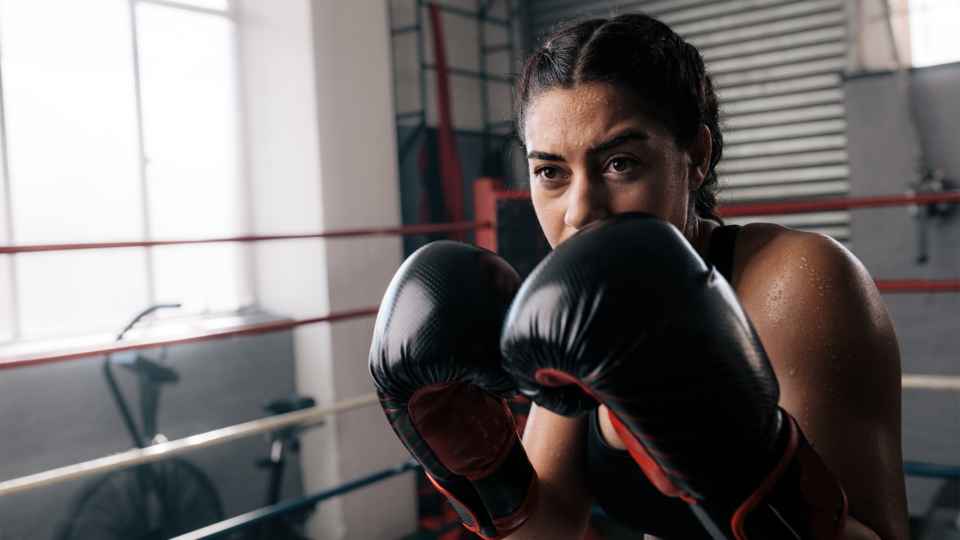 woman in a boxing ring with gloves on