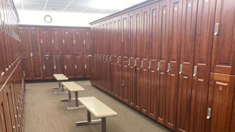 Dark lockers with benches in locker room