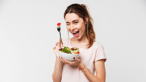 Woman holding a salad and winking