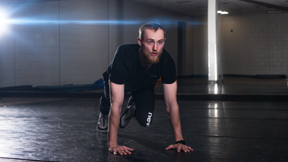 male personal trainer performing mountain climbers indoors
