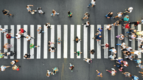 a group of people crossing a street from an aerial view