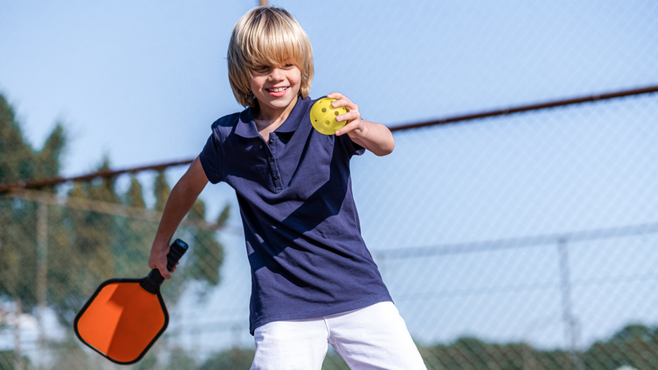 young boy playing pickleball