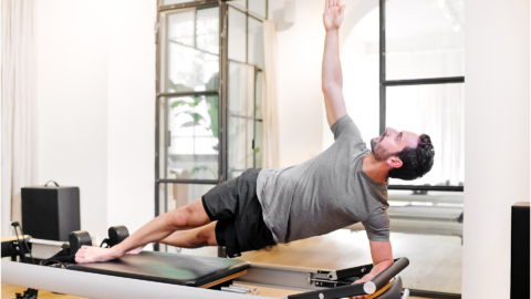 male performing pilates in a studio