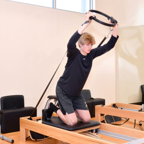 Teenage Boy using pilates reformer