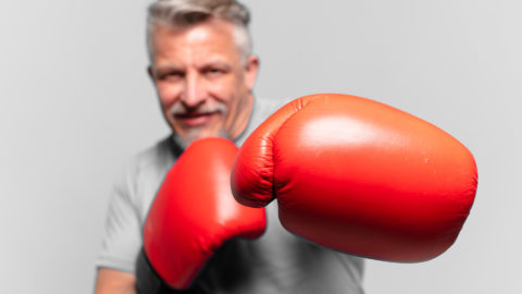 Man punching towards the camera with boxing gloves