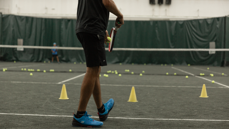 male athlete playing tennis on indoor clay courts