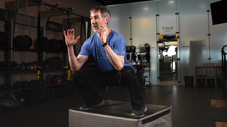 personal trainer David Nutting performing box jumps in studio
