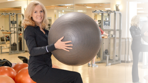 women balancing on one leg with exercise ball