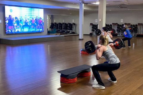 Women taking a virtual les mills group fitness class