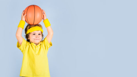 little boy with basketball over his head