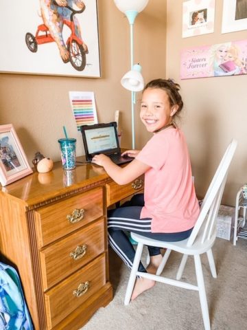 young girl sitting at a desk focusing on school work
