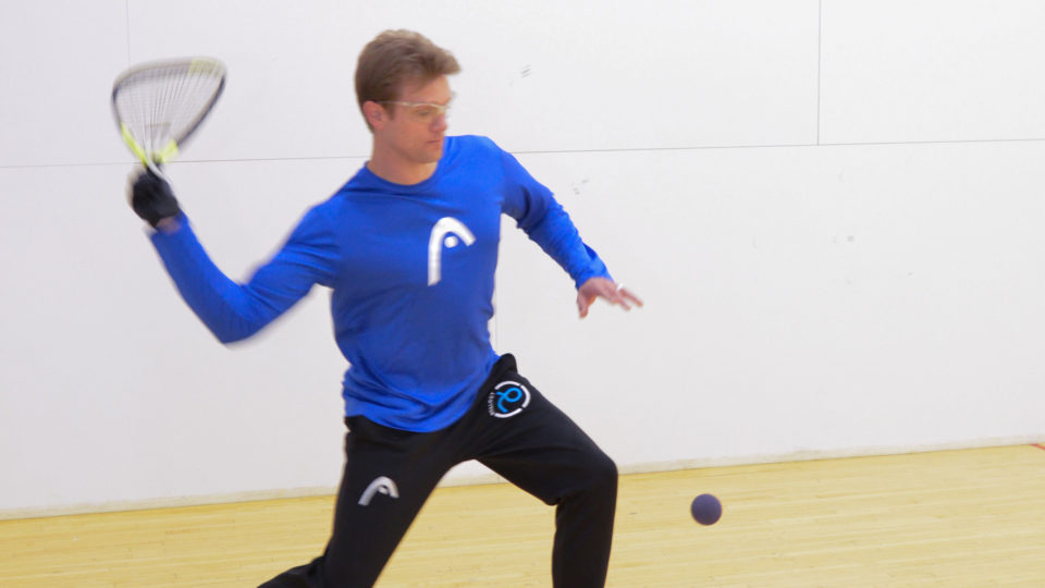 Man in blue shirt playing racquetball