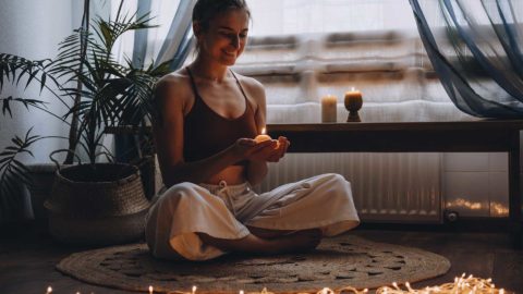 woman sitting with a candle and smiling