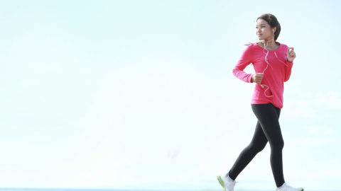 woman wearing a pink sweatshirt going for a run outside