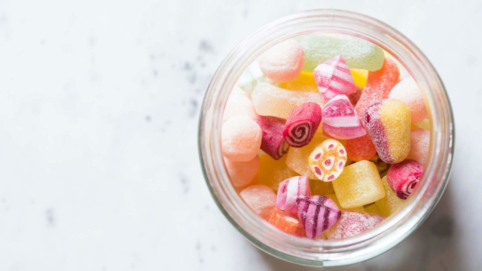 colorful candy in a jar sitting on a marble table top