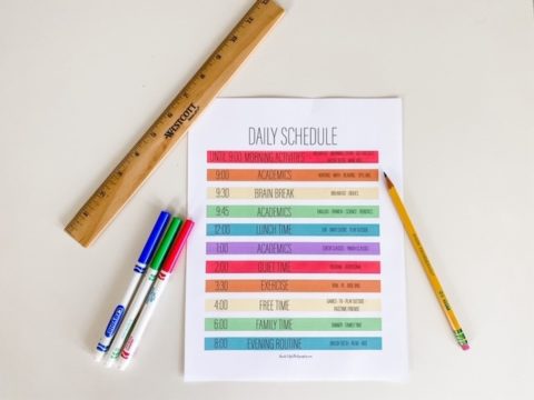 a paper that says daily schedule with a ruler, pencil, and colorful markers