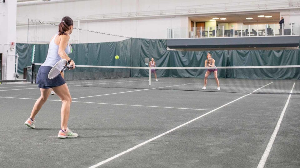 Women playing doubles tennis at Club Greenwood