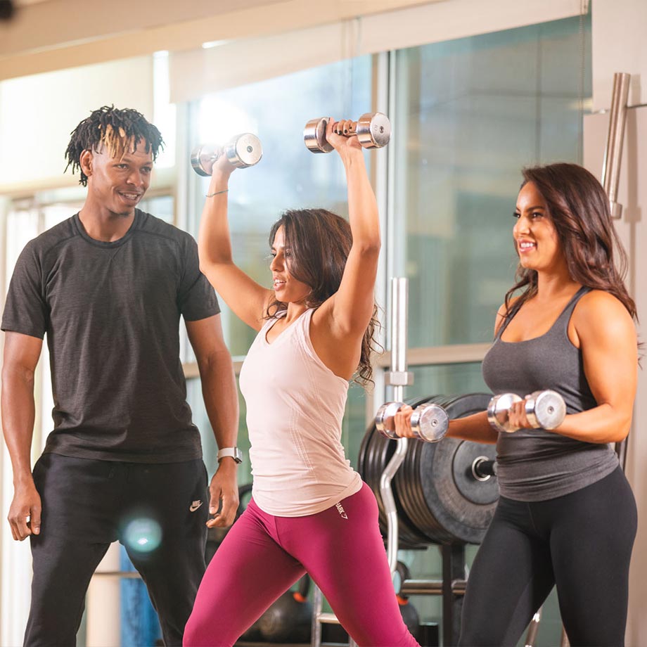 club greenwood personal trainer brandon smith training two women in the weight room